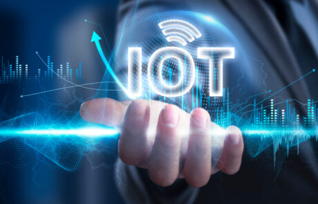 Visualisierung des Begriffs „IoT“ in einer holografischen Darstellung über der geöffneten Hand einer Businessperson.